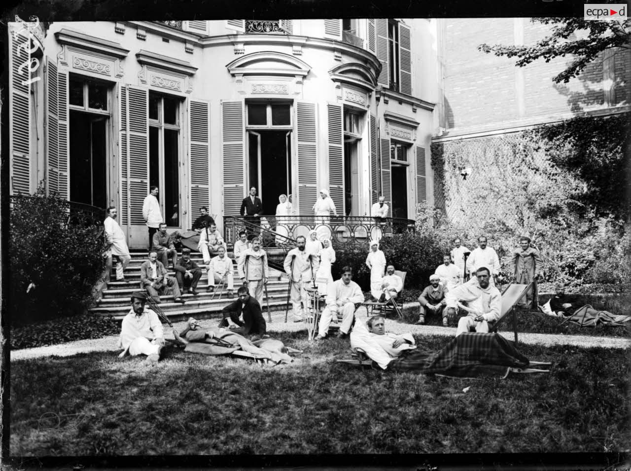 Paris. Hôpital auxiliaire n°232, rue de la Boetie. Dans le jardin. Blessés et infirmières. [légende d'origine]