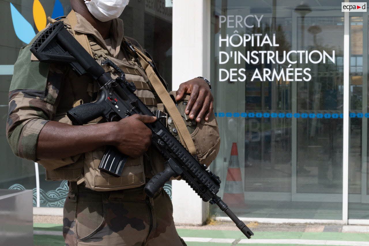 Un élément du 2e régiment du service militaire volontaire (2e RSMV) patrouille devant l'entrée de l'hôpital d'instruction des armées (HIA) Percy, à Clamart.