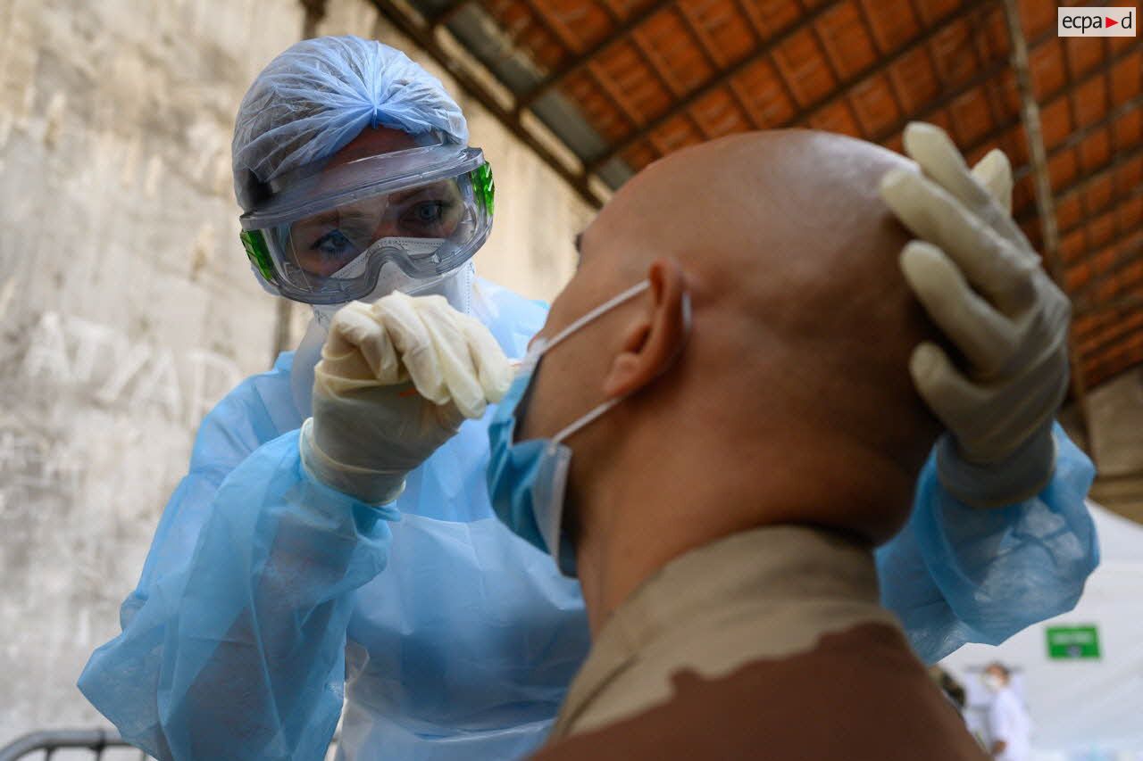 Une infirmière de l'hôpital d'instruction des armées (HIA) Bégin pratique un test de dépistage de la Covid-19 sur un soldat de retour d'opération extérieure.