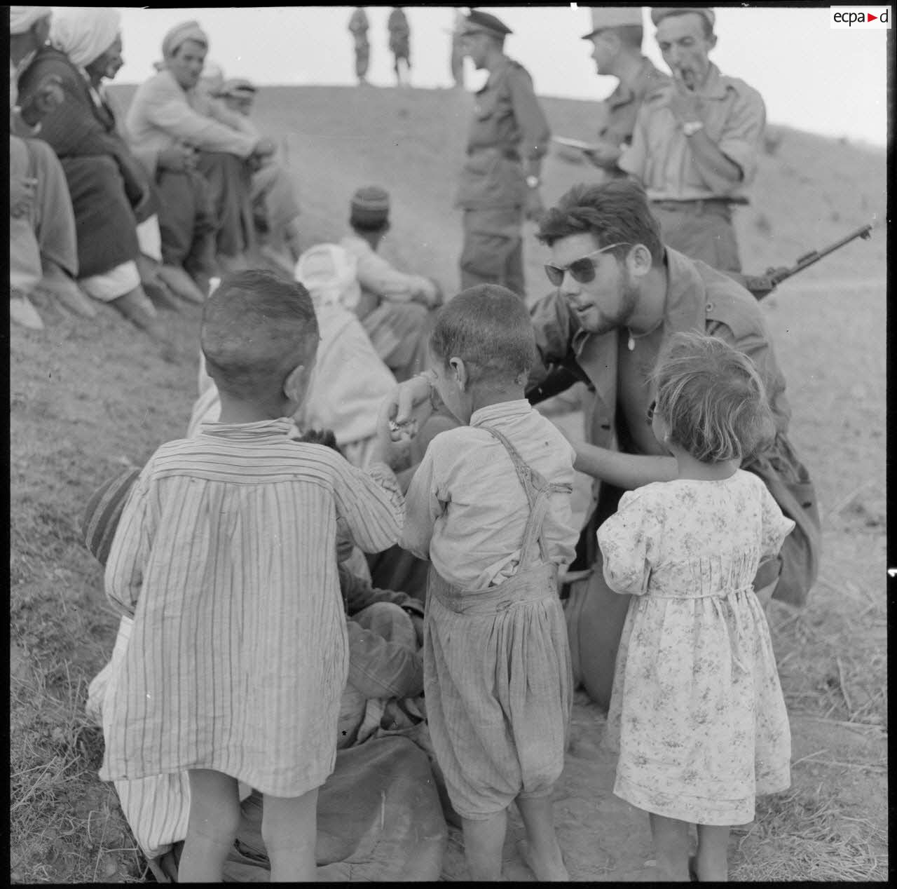 L'infirmier du 1er bataillon de la 1re demi-brigade de fusiliers-marins (DBFM) distribuant des bonbons aux enfants de Beni Menir.