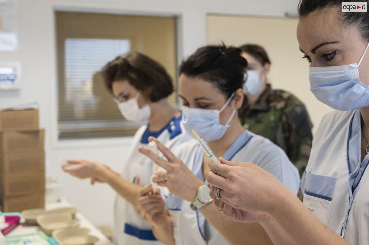 Des infirmières de l'hôpital d'instruction des armées (HIA) Bégin préparent des doses de vaccin Pfizer-BioNTech contre la Covid-19.