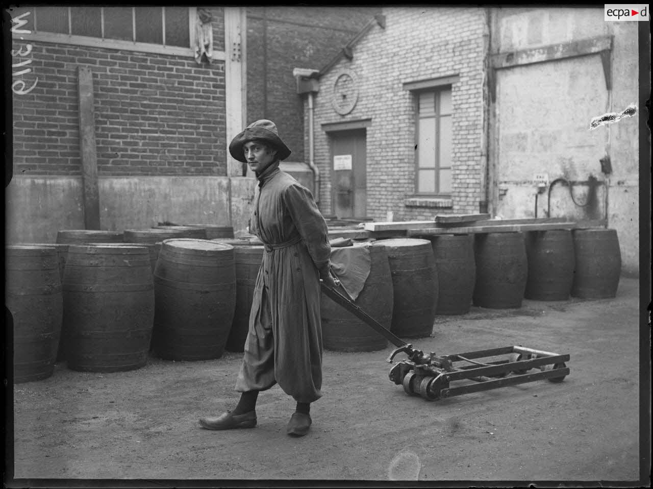 Usines Citroën du quai de Javel. Femme en culotte traînant un petit chariot. [légende d'origine]