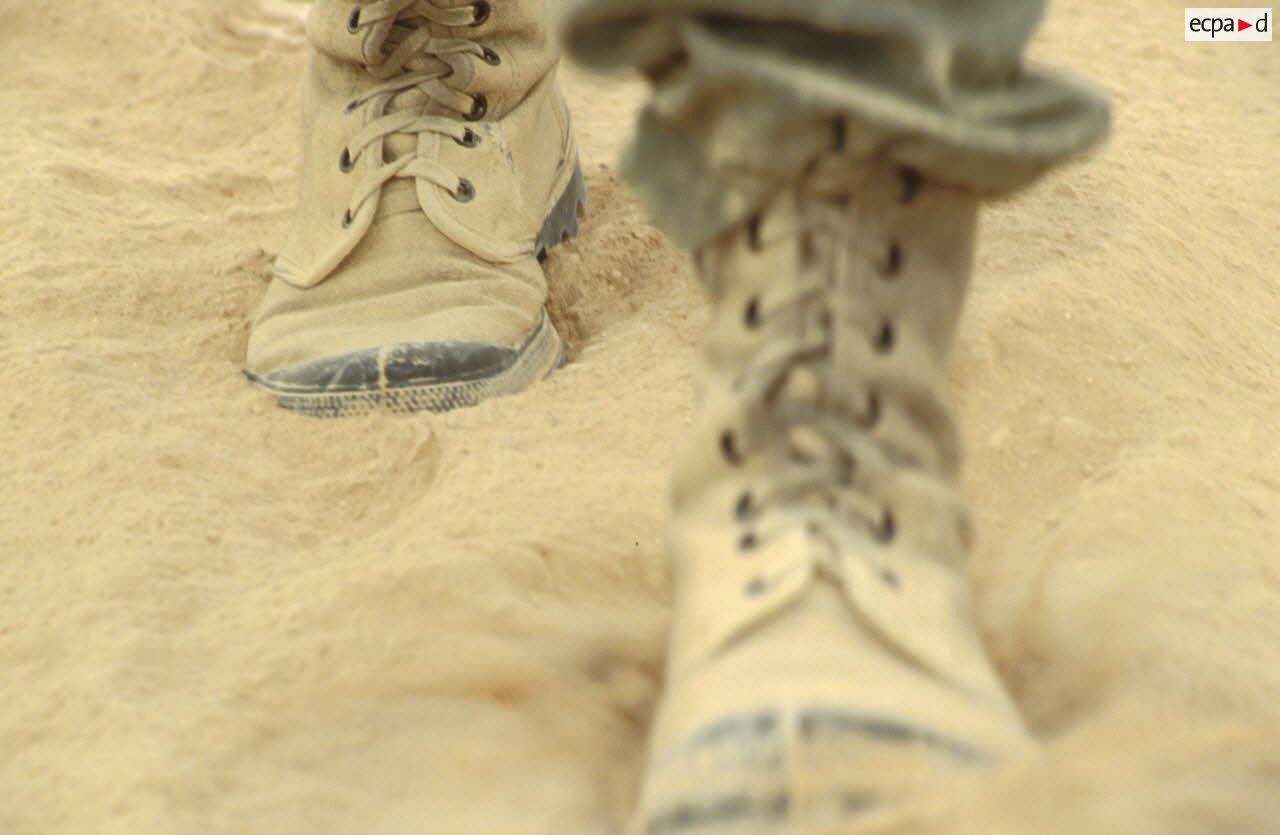 Gros plan de Pataugas dans le sable.