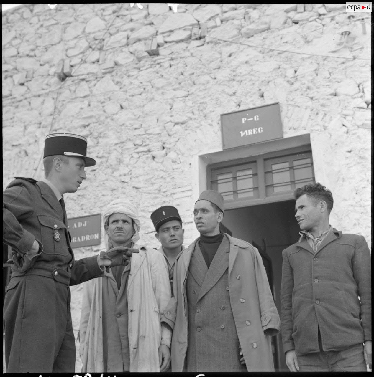 Un officier français discute avec trois harkis lors de leur engagement à Bou-Saâda.