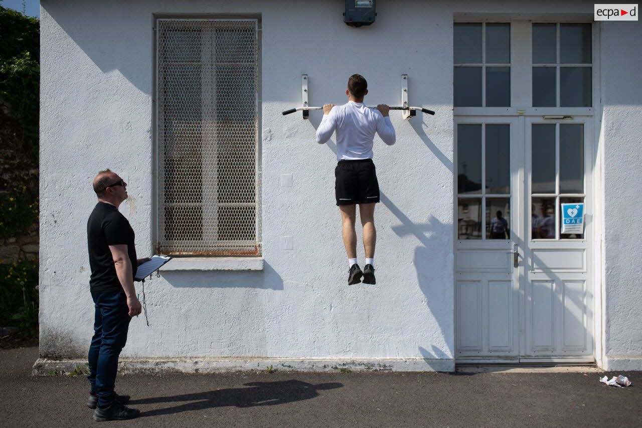 Un élève en classe préparatoire effectue des tractions sous la supervision de son professeur d'éducation physique et sportive (EPS) au lycée militaire d'Autun.