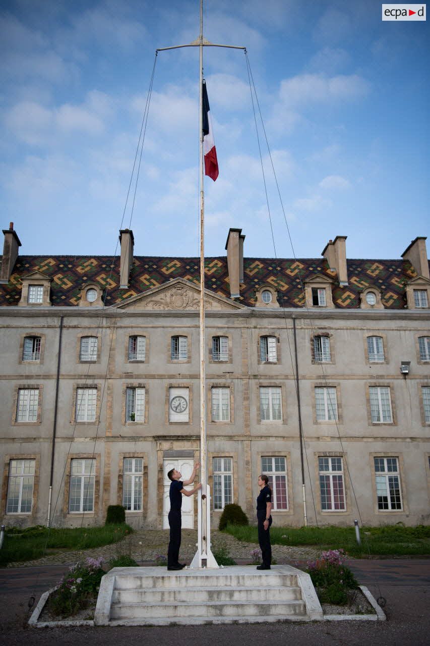 Des gardes au drapeau hissent les couleurs lors d'une cérémonie au lycée mitlitaire d'Autun.