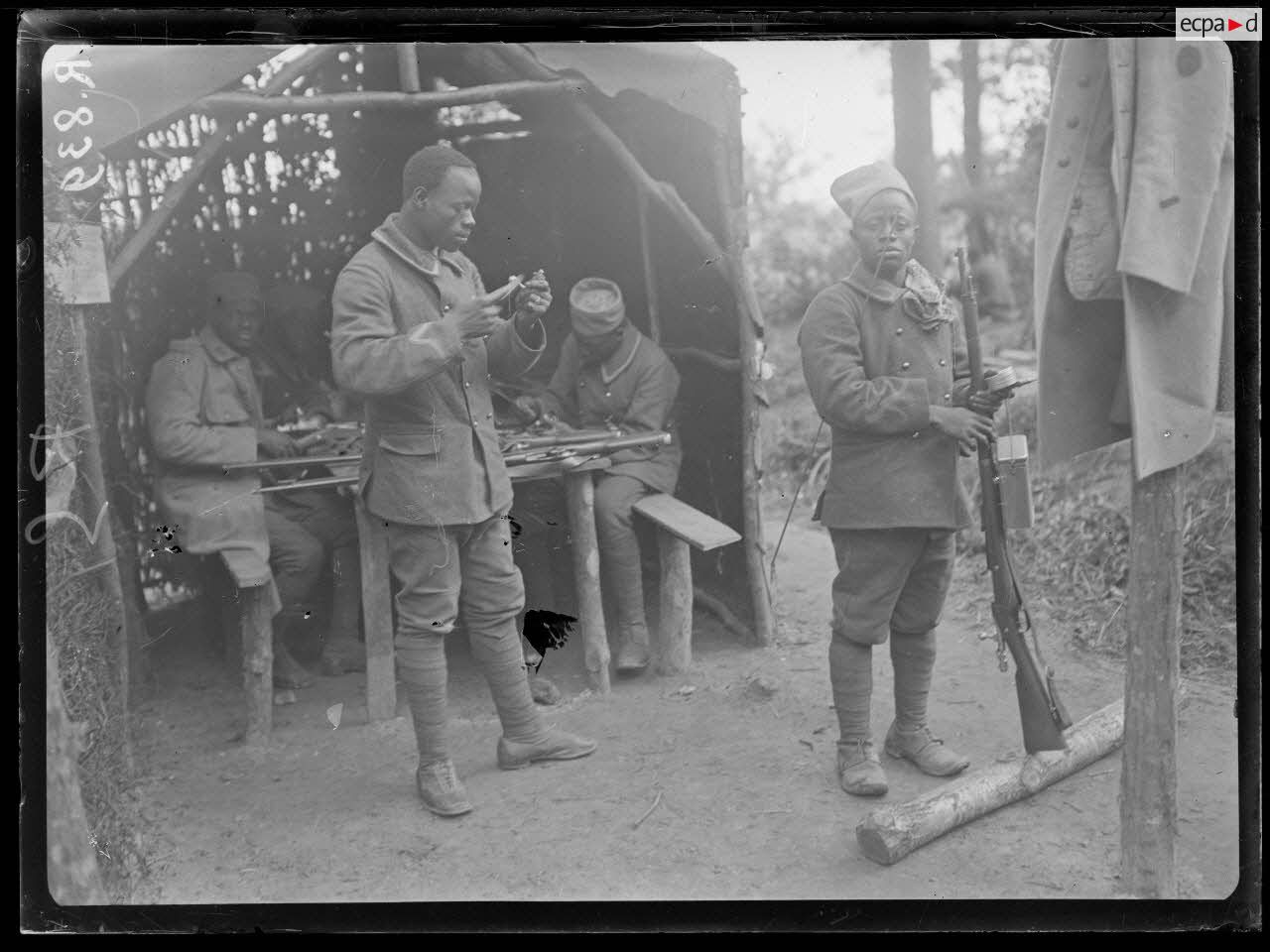 Bois d'Houssoy, près de Remaugis (Somme). Camp de tirailleurs sénégalais, 62e bataillon, Sénégalais nettoyant leurs fusils. [légende d'origine]