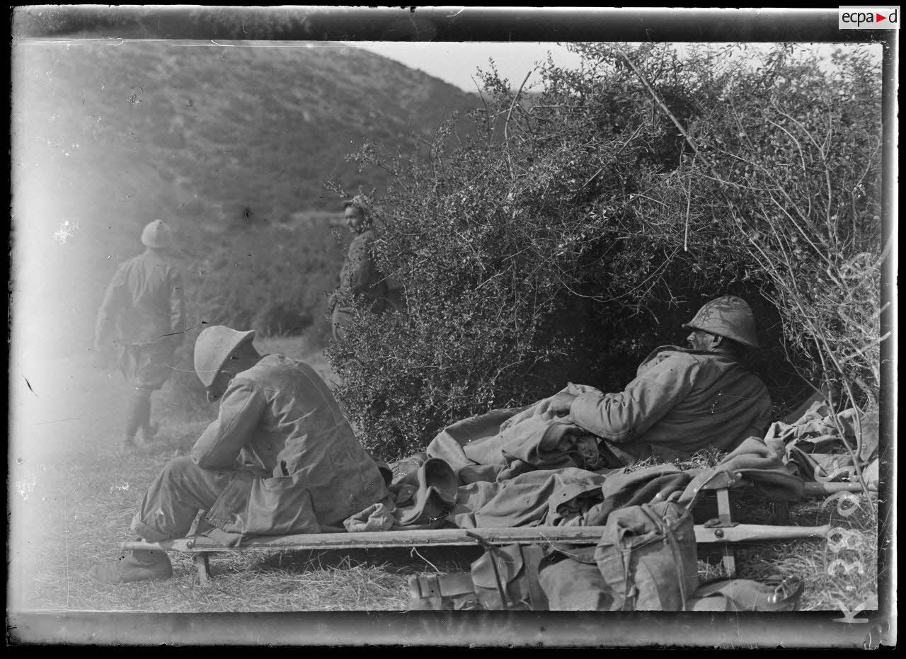 Ravin de Valadja (Macédoine). Poste de secours, un blessé couché sur un brancard et un fiévreux assis. [légende d'origine]