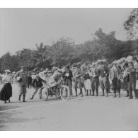 [1899. Paris, bois de Boulogne. La course des artistes. Un tricycle au départ].