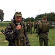 Compte-rendu radio russe et briefing multinational au PC tactique.