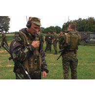 Compte-rendu radio russe et briefing multinational au PC tactique.