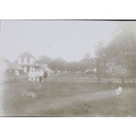 [Scène de rue dans un village avec bâtiments coloniaux, s. d.]