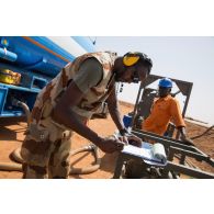 Le brigadier-chef Anthony du Service des essences des armées (SEA) encadre la livraison de carburéacteur par un camion-citerne nigérien au dépôt militaire de Niamey, au Niger.