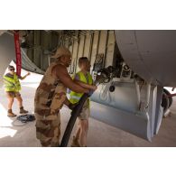 Un soldat du Service des essences des armées (SEA) aide les aviateurs du groupement de transport opérationnel (GTO) pour l'avitaillement en carburant d'un avion Boeing C-135FR Stratotanker à NIamey, au Niger.