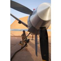 Le brigadier Arthur du Service de santé des armées (SEA) avitaille un drone General Atomics MQ-9 Reaper de l'escadron de drones 1/33 Belfort à Niamey, au Niger.