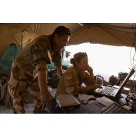 Le maréchal des logis Margaux et le brigadier-chef Christian paramètrent une valise satellitaire broaddbang global area network (BGAN) au poste de commandement tactique (PCTAC) de Madama, au Niger.