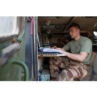 Le lieutenant Nicolas du Service des essences des armées (SEA) travaille à l'arrière de son véhicule de l'avant blindé (VAB) à Madama, au Niger.