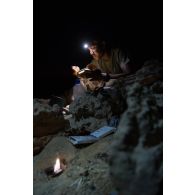 Le brigadier-chef Jean du Service des essences des armées (SEA) mange sa ration de combat en bivouac à Madama, au Niger.