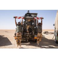 Des soldats du Service des essences des armées (SEA) font des tractions à l'arrière d'un camion lourd de dépannage (CLD) TRM-10000 à Madama, au Niger.