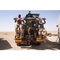 Des soldats du Service des essences des armées (SEA) font des tractions à l'arrière d'un camion lourd de dépannage (CLD) TRM-10000 à Madama, au Niger.