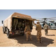 Des soldats du Service des essences des armées (SEA) avitaillent un hélicoptère Caracal EC-725 en carburant depuis leur camion-citerne CBH-385 sur la piste de Madama, au Niger.