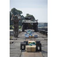 Un élément du peloton de transport et maintenance (PTM) du 511e régiment du train (511e RT) guide le chargement d'un véhicule blindé de combat d'infanterie (VBCI) à bord d'un train en gare de Gaiziunai, en Lituanie.