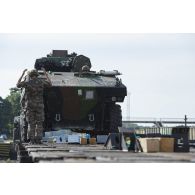 Un élément du peloton de transport et maintenance (PTM) du 511e régiment du train (511e RT) guide le chargement d'un véhicule blindé de combat d'infanterie (VBCI) à bord d'un train en gare de Gaiziunai, en Lituanie.