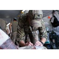 Une infirmière du 250e FST (forward surgical team ou équipe chirurgicale de campagne) examine la blessure d'un bigor du SGTA (sous-groupement tactique d'artillerie) Lion du 3e RAMa intégré à la Task Force Wagram, dans le cadre d'un exercice MASCAL (mass casualties ou afflux de blessés) entrepris conjointement avec les forces françaises et américaines présentes sur le camp militaire de la ville irakienne d'Al-Qaïm, située à proximité de la frontière avec la Syrie.