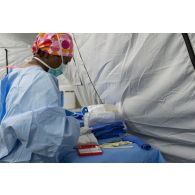 Un élément du personnel médical du 250e FST (forward surgical team ou équipe chirurgicale de campagne) prépare le matériel nécessaire à l'opération d'un soldat blessé dans le cadre d'un exercice MASCAL (mass casualties ou afflux de blessés) entrepris conjointement avec les forces françaises et américaines présentes sur le camp militaire de la ville irakienne d'Al-Qaïm, située à proximité de la frontière avec la Syrie.