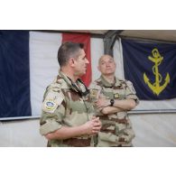 Le vice-amiral d'escadre Olivier Coupry, inspecteur général des armées, au côté du colonel Pierrick Michel, chef de corps du 3e RAMa intégré à la Task Force Wagram, s'adresse aux officiers des forces de la coalition lors d'un discours durant sa visite au camp Leclerc de la base aérienne Al-Asad Air Base (AAAB).