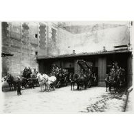 Les voitures attelées de la grande échelle des sapeurs-pompiers à l'entrée de leur garage dans la caserne. [légende d'origine]