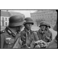 A Thulin (Belgique), entre Mons et Valenciennes, devant la maison communale, un groupe de soldats allemands du 469 I.R (Infanterie Regiment) examine un pistolet français 7,65 mm "Ruby" qu'ils viennent de saisir lors de la prise du village.