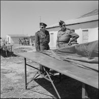 Général de brigade et commandant parachutistes observant des toiles de parachutes lors du 27e Congrès national des officiers de réserve à Constantine.