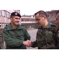 L'officier de liaison français serre la main d'un membre du TMK.