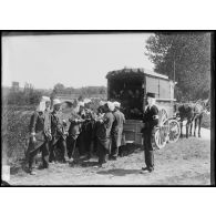 Les soldats du Service de santé placent un blessé dans un compartiment de la voiture médicale attelée, sur la partie latérale du véhicule est inscrit "grande voiture pour blessé modèle 1874". [légende d'origine]