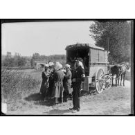 Les soldats du Service de santé placent un blessé dans un compartiment de la voiture médicale attelée, sur la partie latérale du véhicule est inscrit "grande voiture pour blessé modèle 1874" (autre vue). [légende d'origine]