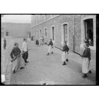 Un groupe de zouaves s'exerce à l'escrime à la baïonnette dans la cour de la caserne. [légende d'origine]