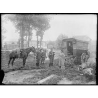 Deux officiers sont en discussion avec une femme (bohémienne) vivant dans une roulotte, ses deux enfants jouent à ses pieds. [légende d'origine]