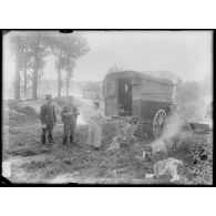 Deux officiers sont en discussion avec une femme (bohémienne) vivant dans une roulotte, ses deux enfants jouent à ses pieds (autre vue). [légende d'origine]