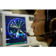 Portrait d'un sergent opérateur d'ESM (electronic support measure ou système d'écoute d'émissions) devant son écran radar, lors d'une mission de contrôle aérien sur la Libye à bord d'un avion de détection Awacs.