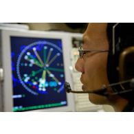 Portrait d'un sergent opérateur d'ESM (electronic support measure ou système d'écoute d'émissions) devant son écran radar, lors d'une mission de contrôle aérien sur la Libye à bord d'un avion de détection Awacs.