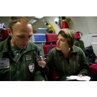 Interview du lieutenant-colonel Arnaud Bourguignon, chef de mission E3F (tactical director), par une journaliste, lors d'une mission de contrôle aérien sur la Libye à bord d'un avion de détection Awacs.