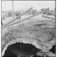 Cratère causé par l'explosion d'une bombe sur le boulevard de la République à Alger lors du bombardement allemand de la nuit du 18 au 19 avril 1943.