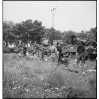 Des chasseurs du 5e RCA (régiment de chasseurs d'Afrique) de la 1re DB (division blindée) inventorient les matériels et lots de bord équipant leurs chars légers Stuart M5 A1 dans un champ en bordure d'une route menant à Blida.