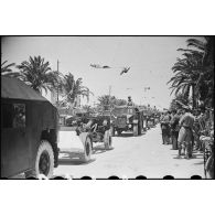 Défilé de tracteurs d'artillerie britanniques Morris C8 tractant des canons de campagne Ordnance QF 25 mm, lors de la cérémonie célébrant la victoire alliée à l'issue de la campagne de Tunisie.