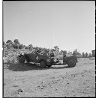 Scout-car M3A1 du 3e Régiment de spahis algériens de reconnaissance (RSAR) à l'entraînement, tractant une remorque blindée M8 au cours d'une manoeuvre du corps expéditionnaire français (CEF) dans le Sud algérien.