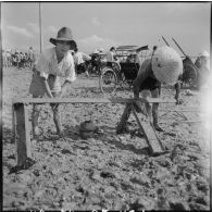 Deux hommes récupèrent la ferraille, jetée par la 11e CMRM (compagnie moyenne de réparation du matériel), dans le fleuve Rouge.