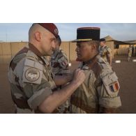 Le colonel Olivier Vidal remet la médaille de l'ordre national du mérite à l'adjudant-chef Benjamin lors de la cérémonie de commémoration du 8 mai 1945 à Gao.