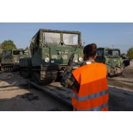 Un soldat guide le chargement d'un véhicule articulé chenillé (VAC) Bandvagn 206 à bord d'un camion porteur polyvalent logistique (PPLOG) à Jõhvi, en Estonie.