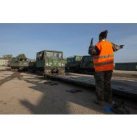 Un soldat guide le chargement d'un véhicule articulé chenillé (VAC) Bandvagn 206 à bord d'un camion porteur polyvalent logistique (PPLOG) à Jõhvi, en Estonie.